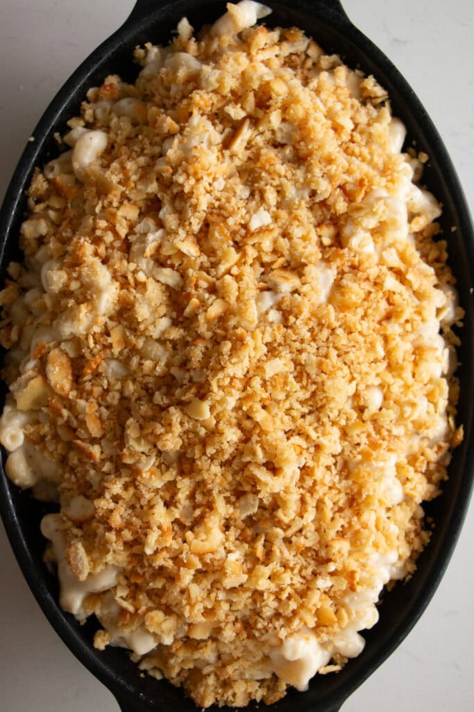 Baking dish with mac and cheese mixture topped with cracker topping