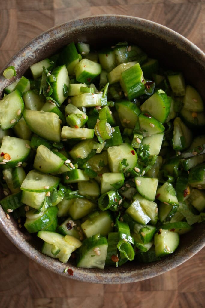 Bowl with chopped cucumber, cilantro, green onions, and sesame seeds.