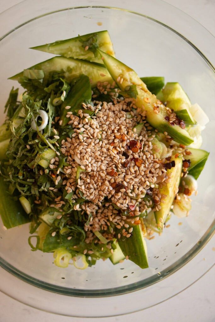 mixing bowl with cucumber salad and sesame seeds 