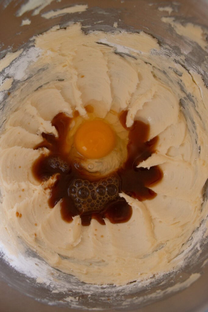 creamed butter in a mixing bowl with eggs and vanilla