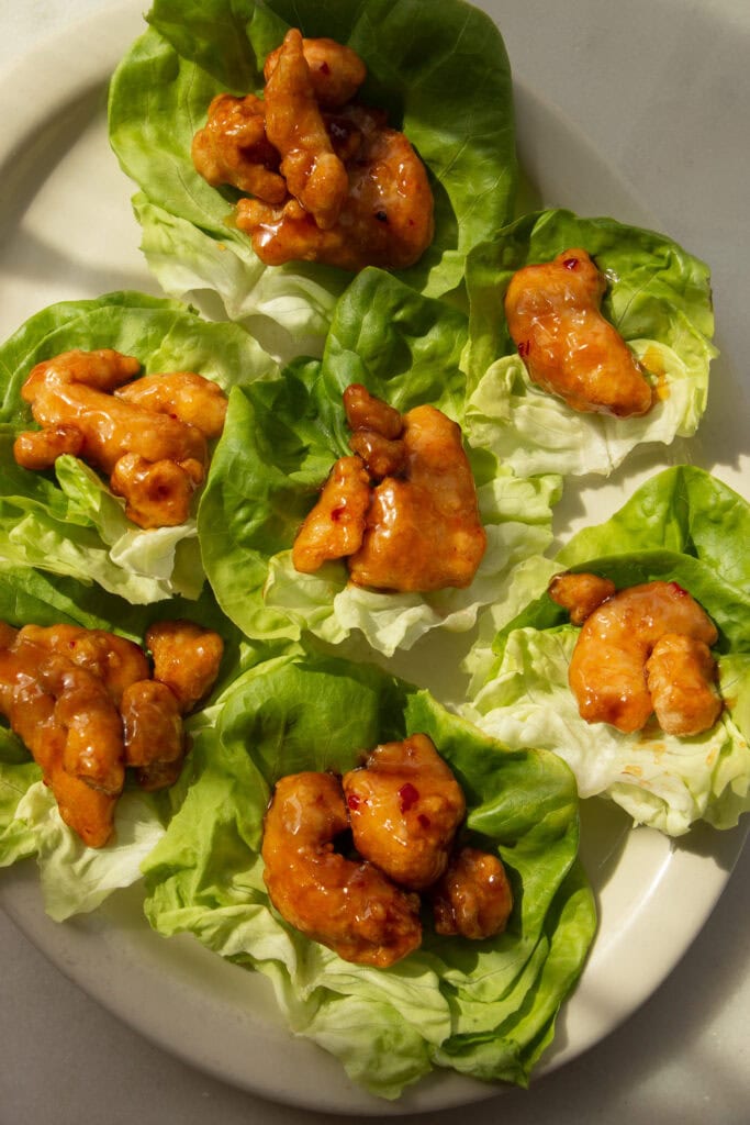lettuce cups on a platter filled with crispy chicken