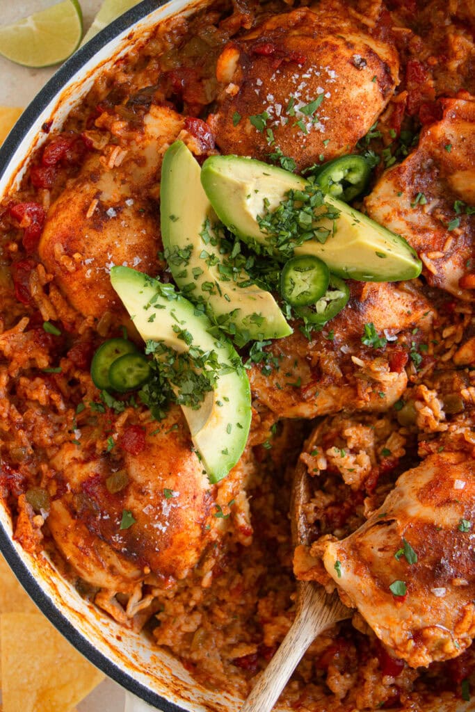 Mexican chicken and rice skillet with avocado slices, fresh cilantro, and jalapeno slices. 