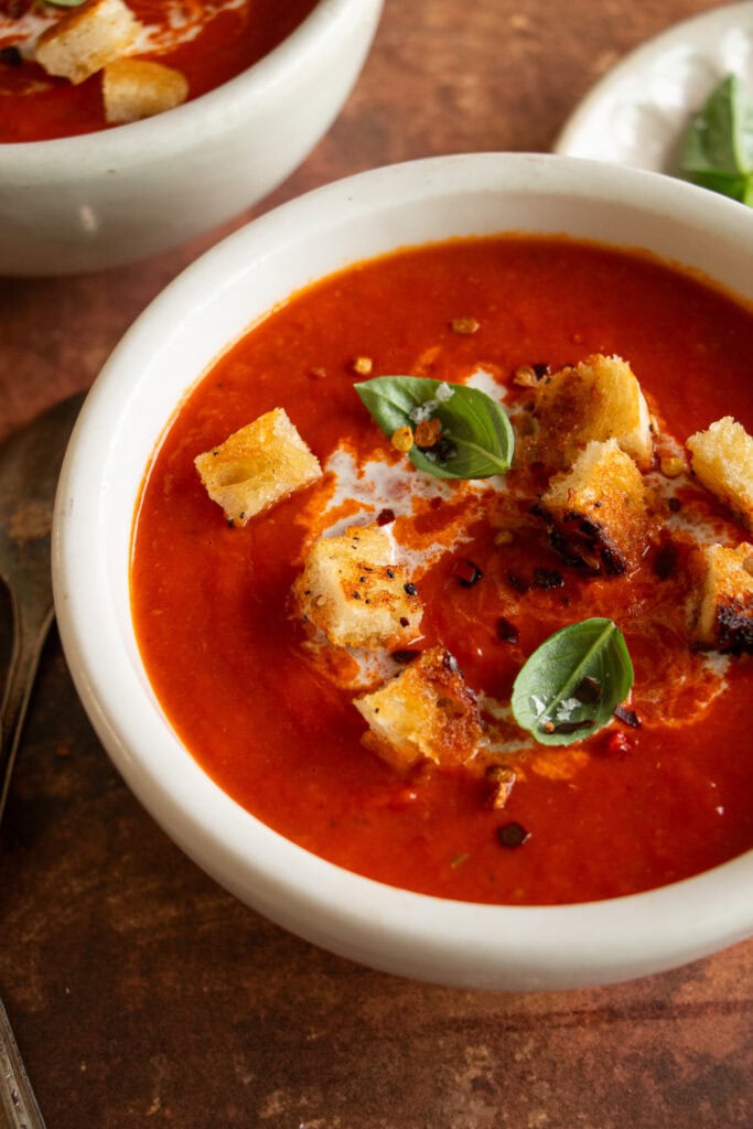 creamy tomato soup with crispy bread and a drizzle of cream 