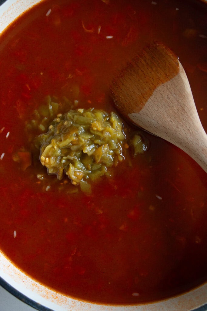 Skillet with liquid mixture and diced chiles 