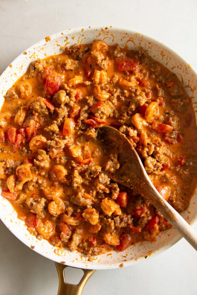 Sauté pan with creamy Cajun cream sauce, tomatoes, shrimp, and sausage. 