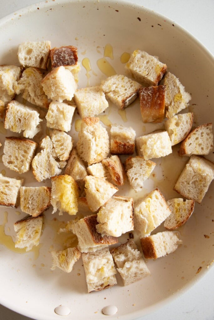 Italian bread cubes in a sauté pan with olive oil 