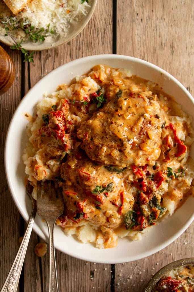 bowl of mashed potatoes topped with Tuscan chicken thighs 