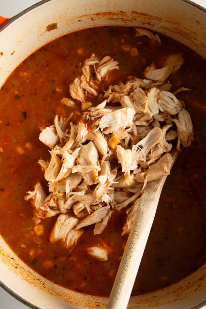 Shredded chicken mixing into the soup