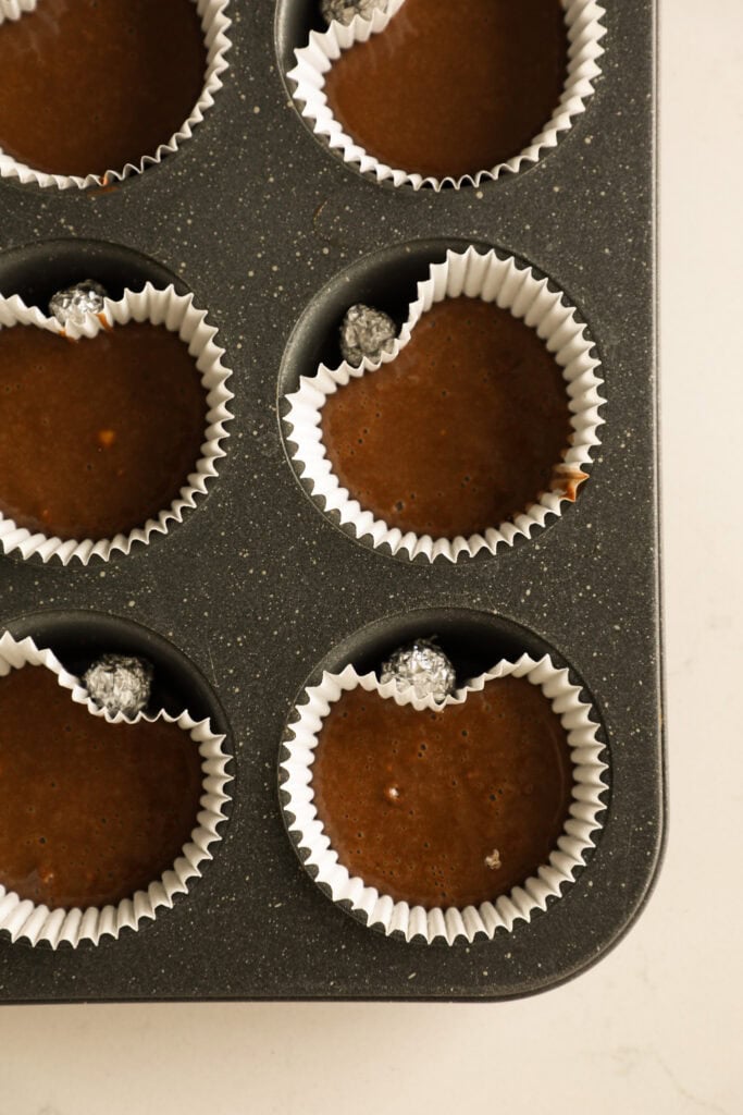 Lined muffin tin with cupcake batter