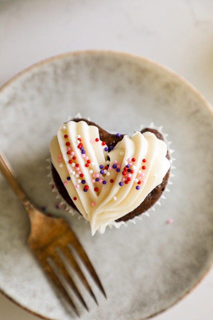 frosted heart cupcake topped with frosting.