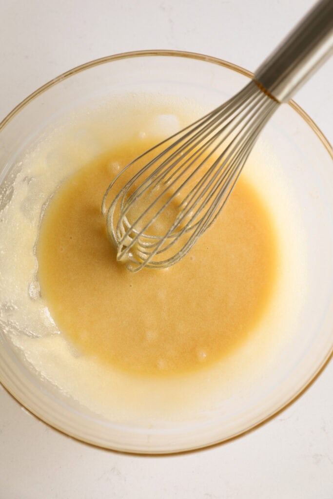 Mixing bowl with cupcake batter and a whisk