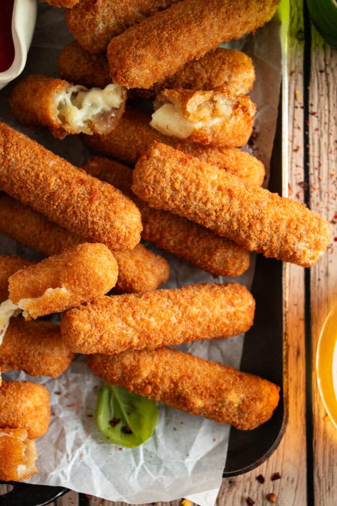 tray full of air fryer mozzarella sticks with dipping sauce