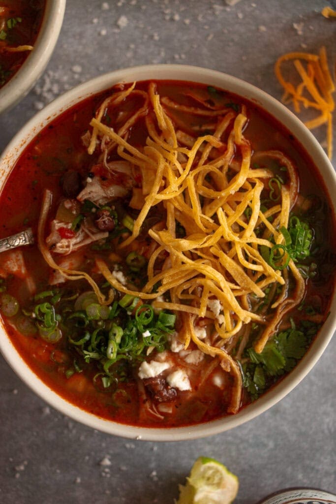 Overhead shot of a bowl of chicken tortilla soup topped with tortilla strips