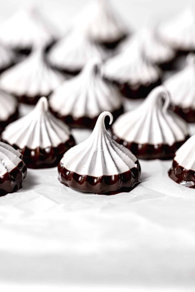 piped meringue cookies on parchment paper