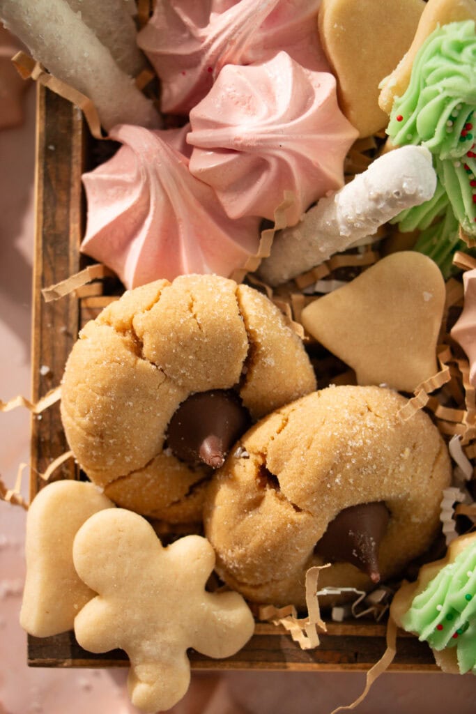Wooden box full of peanut butter blossoms, pretzels, and meringues