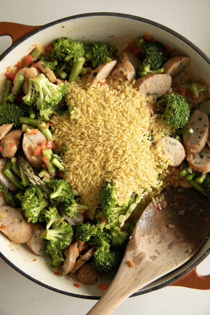 dry orzo added on top of the cooked veggies and sausage