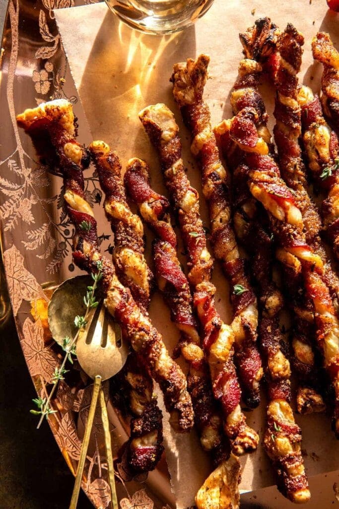 Bacon wrapped puff pastry sticks on parchment