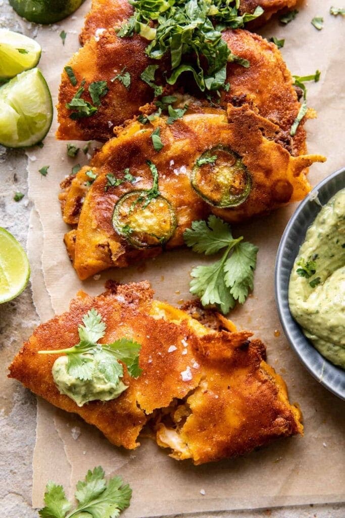 Crispy cheese chicken tacos with fresh lettuce and lime on parchment paper
