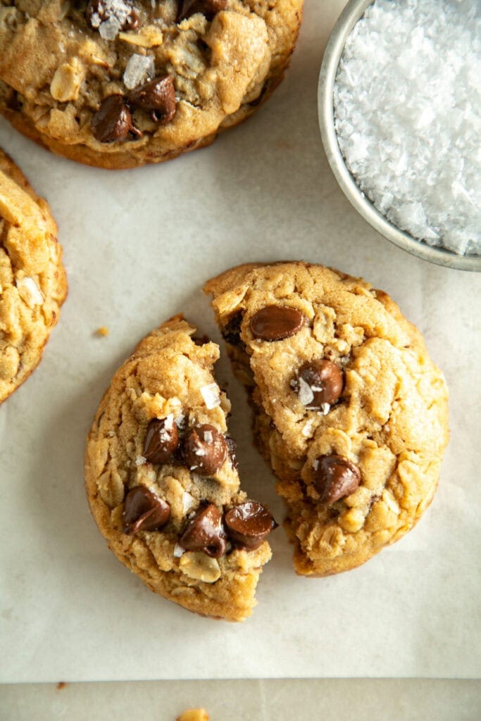 a freshly bake chocolate chip peanut butter oatmeal cookie torn in half