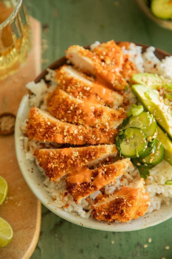 Rice bowl with strips of katsu chicken topped with sriracha aioli