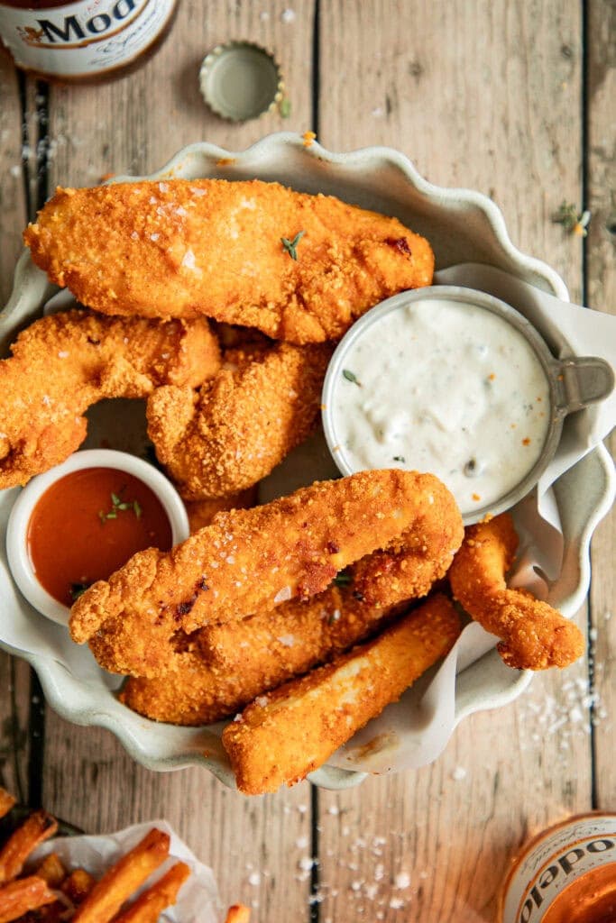 bowl full of chicken strips with dipping sauces