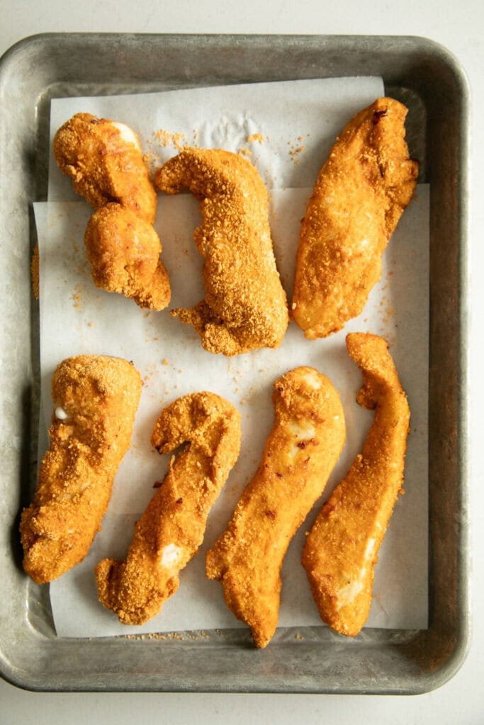 Air fried chicken strips on a sheet pan