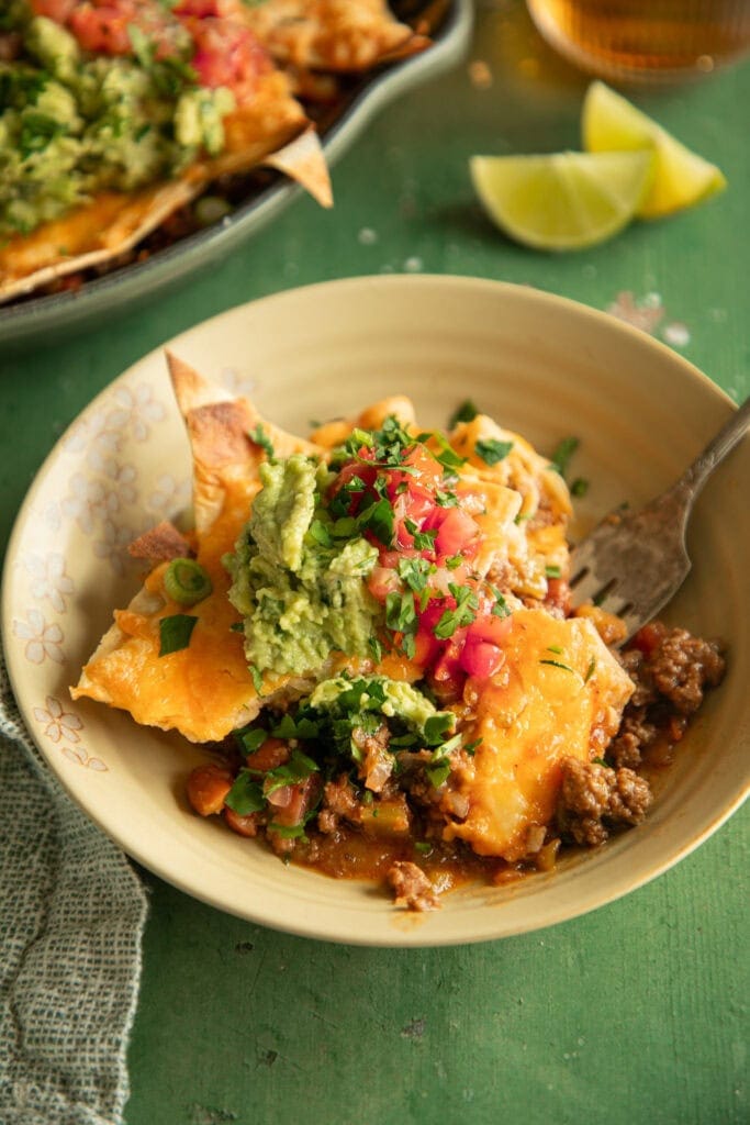 small plate with a scoop of taco bake topped with guacamole and pico