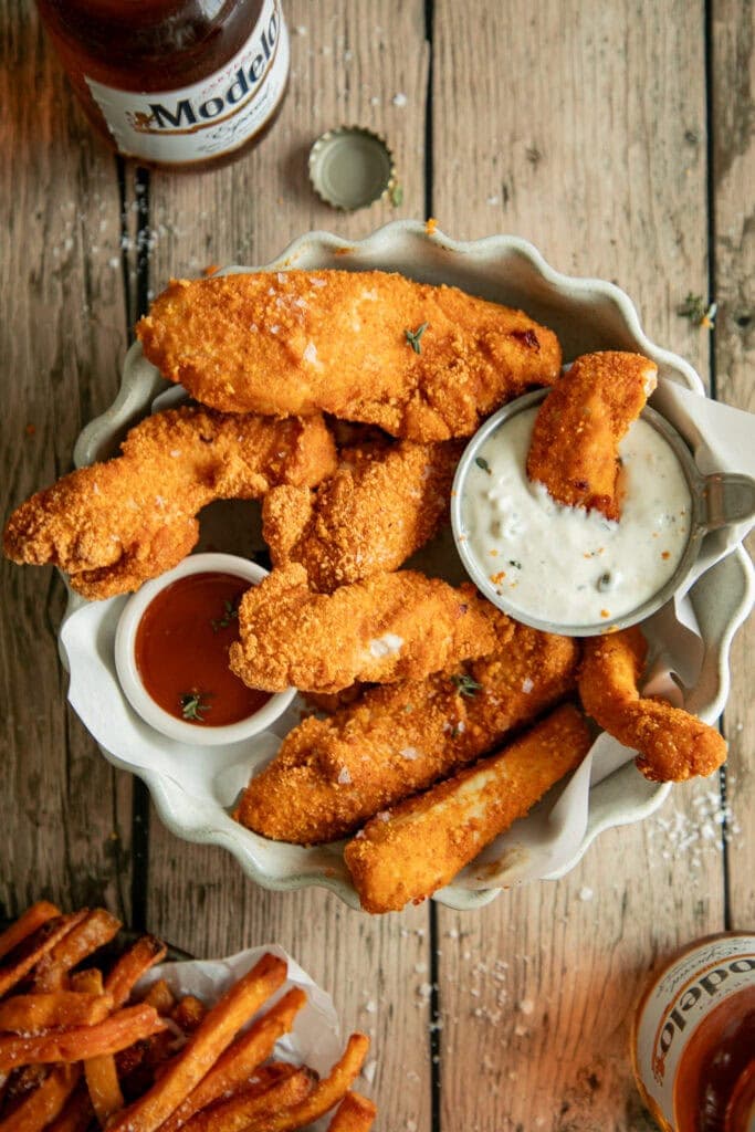 bowl full of chicken tenders with dipping sauce 