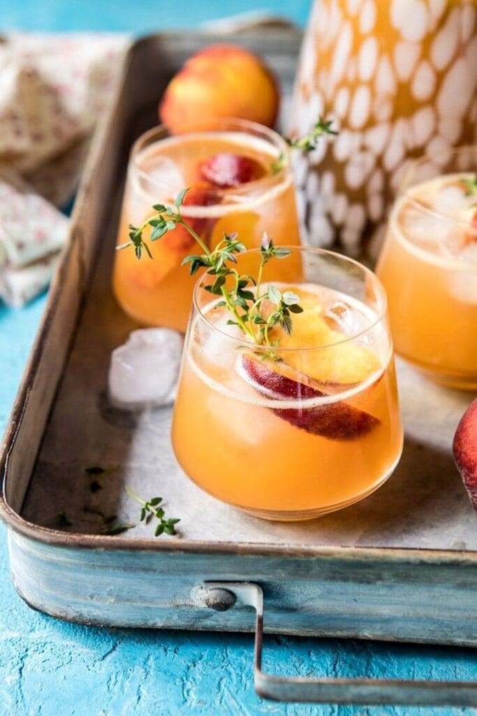 Pitcher and glasses full of whiskey peach lemonade