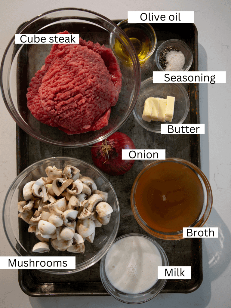 A sheet pan with the prepped and portioned ingredients needed to make the cube steak recipe.