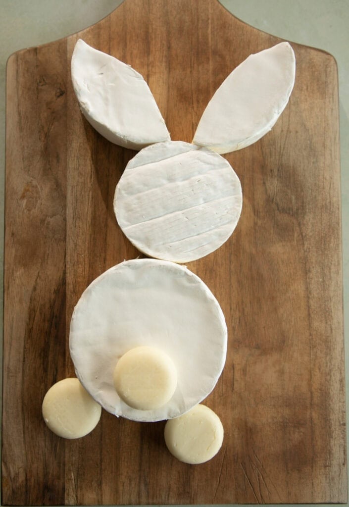 Bunny made with brie cheese wheels and mini baby bell cheese on a board