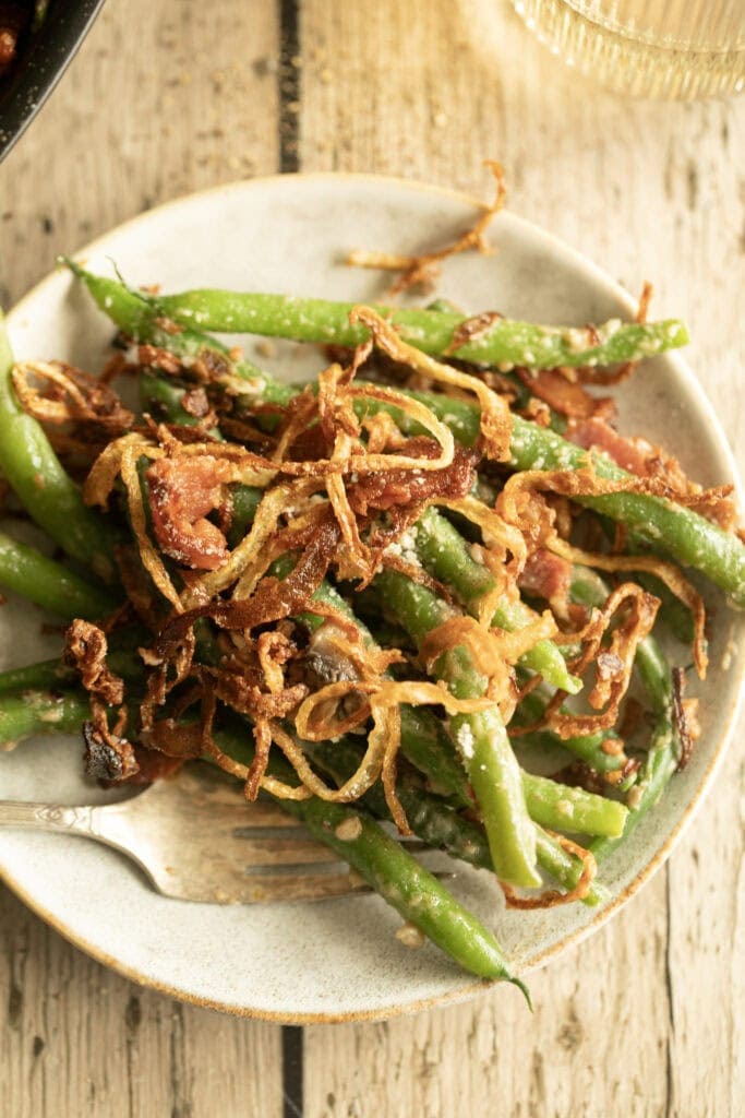 Small plate with a scoop of green bean casserole with crispy onions