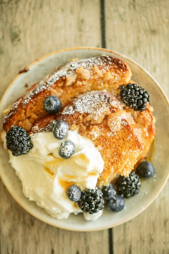 Small plate with slices of Bailey's French toast with berries and whipped cream