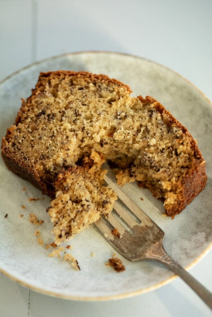 slice of banana bread on a plate with a fork