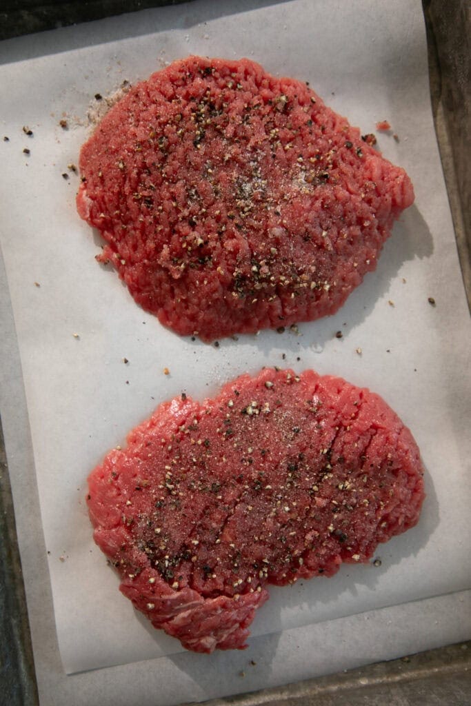 Seasoned cube steaks on a sheet pan