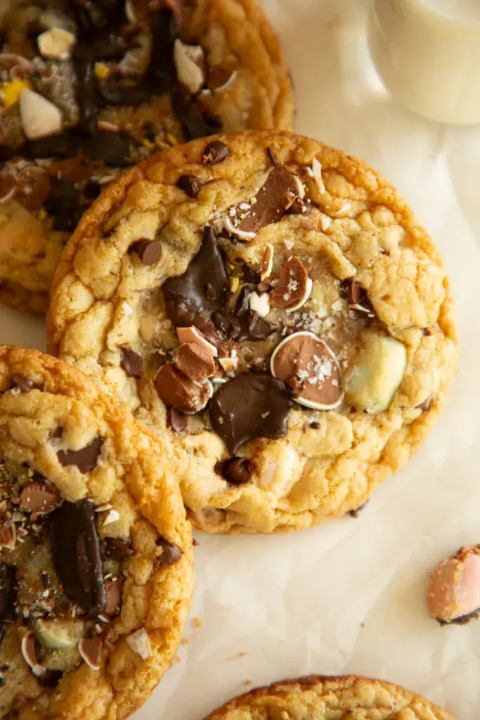 stacked monster cookies with cadbury eggs on parchment paper