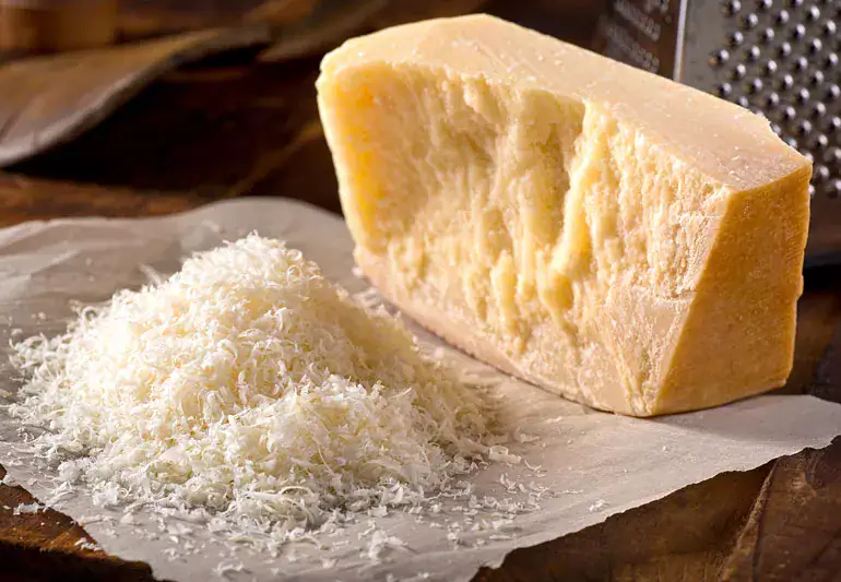 block of parmesan cheese and shredding's