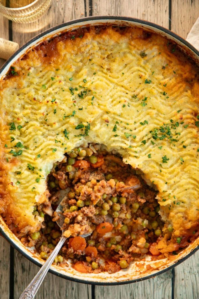 round Dutch oven full of Shepherd's pie with a scoop taken out