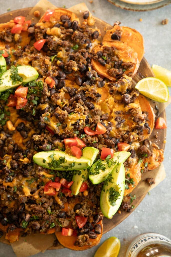 baking pan topped with sliced sweet potatoes and nacho toppings 