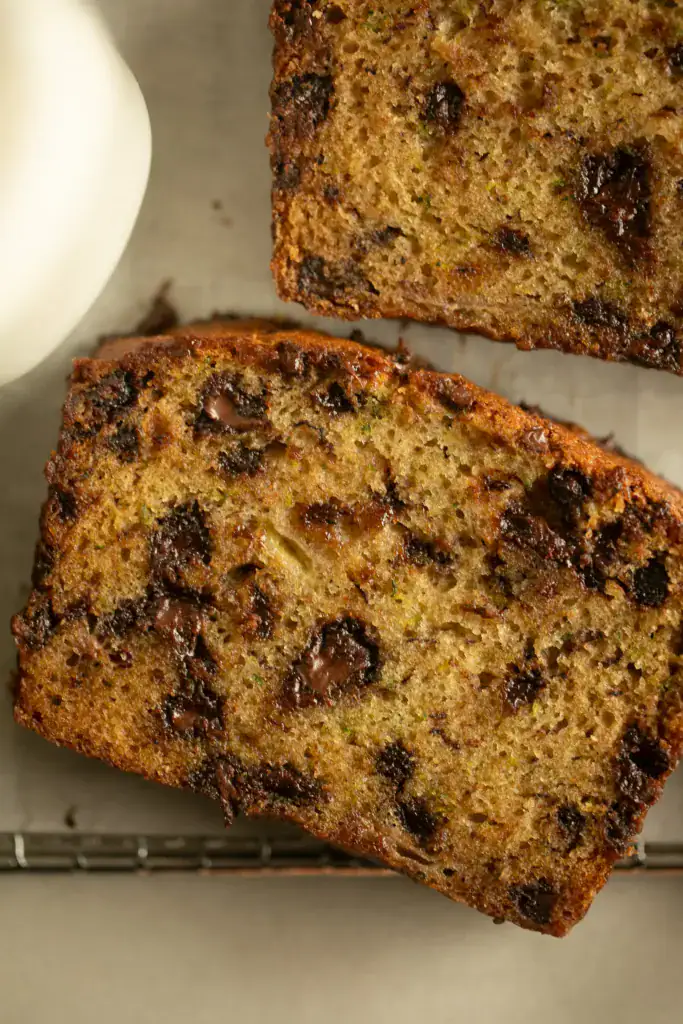 Slices of chocolate chip zucchini bread with a glass of milk