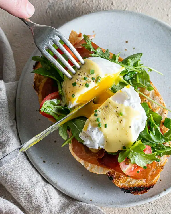 poached eggs over toast with hollandaise and arugula