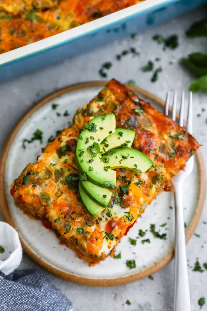 Slice of egg casserole topped with avocado 