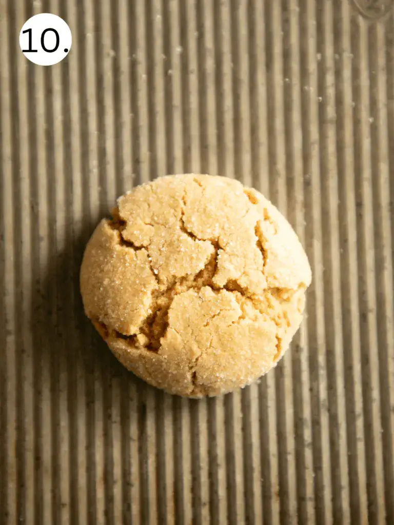 Single baked peanut butter cookie with crackled top on a corrugated baking sheet (Image 10)
