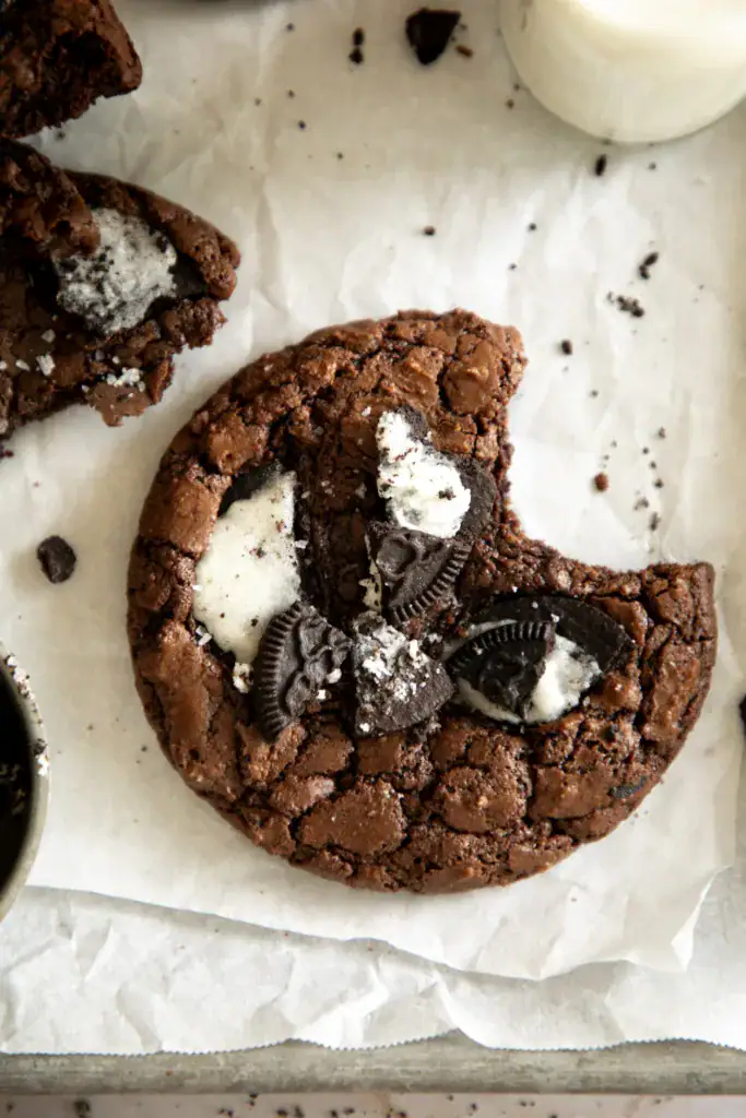 sheet pan with parchment paper on a brownie cookie with a bite taken out