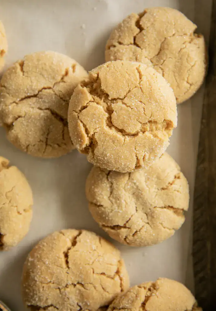 Overhead image of soft peanut butter cookies arranged neatly on baking paper