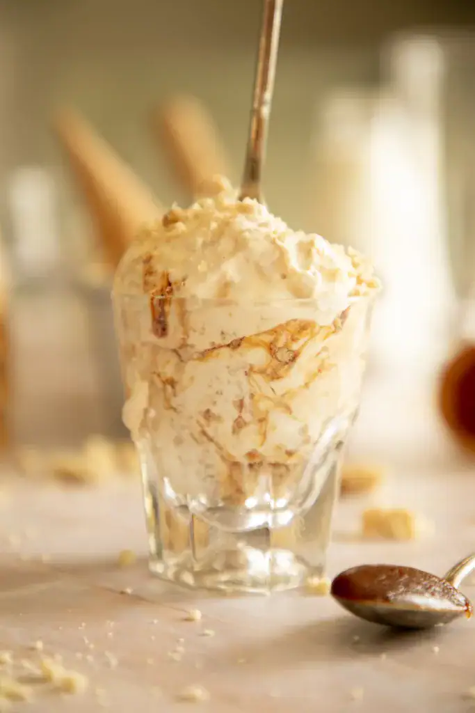 glass cup full of caramel snickerdoodle ice cream with a long spoon