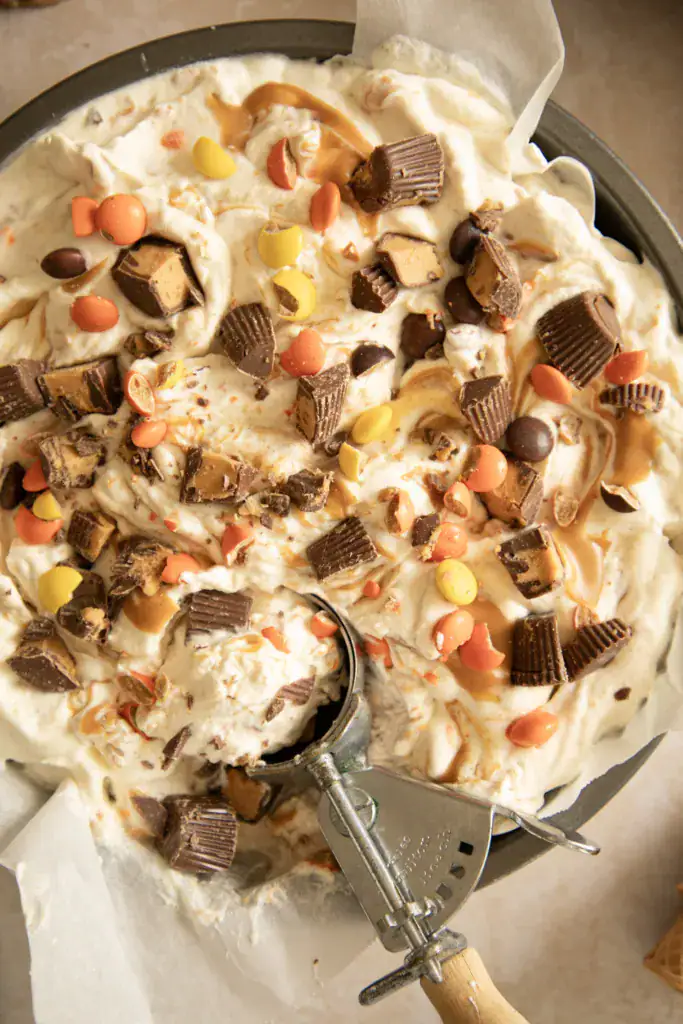 Scooping no-churn peanut butter cup ice cream from a metal pan