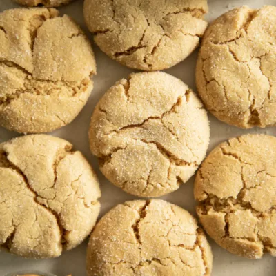 Close-up of soft and chewy peanut butter cookies with a glass of milk and a bowl of peanut butter