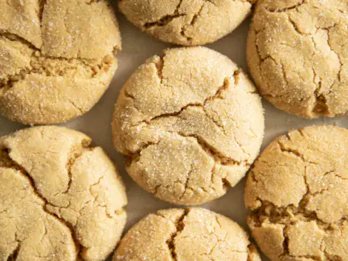 Close-up of soft and chewy peanut butter cookies with a glass of milk and a bowl of peanut butter
