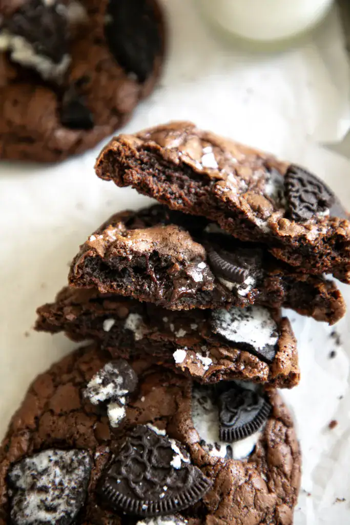 stack of brownie cookies torn in half on parchment paper